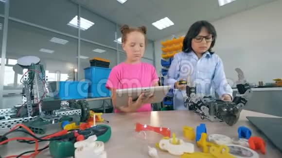 孩子们在制造玩具机器人两个孩子在实验室房间里建造一个机器人视频的预览图