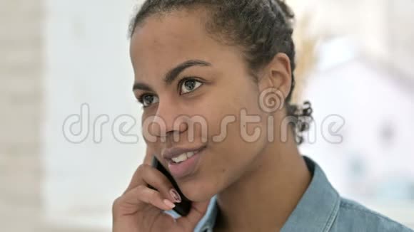 非洲女青年面部特写电话交谈视频的预览图