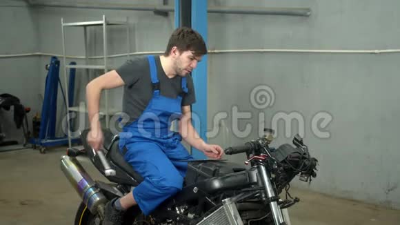 动作慢技师坐在摩托车上修理视频的预览图