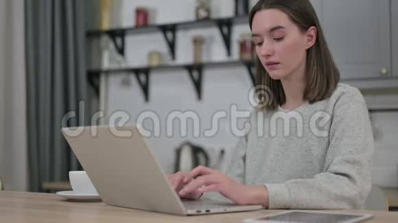 聚焦在客厅笔记本电脑上的年轻女性视频的预览图