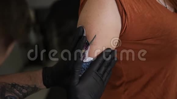 纹身师把素描涂在女人上半身的皮肤上想把色彩斑斓的素描放在女性身上视频的预览图
