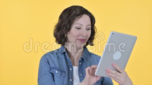 老女人桌上的视频聊天黄色背景视频的预览图