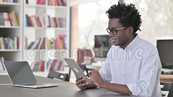 工作中使用数码平板电脑的忙碌非洲男人视频的预览图