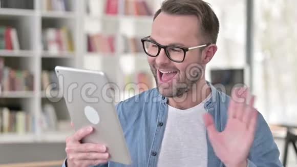 戴眼镜的年轻人在桌上的视频聊天视频的预览图
