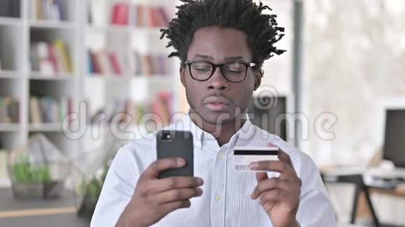 提供智能手机信用卡付款的非洲男子视频的预览图