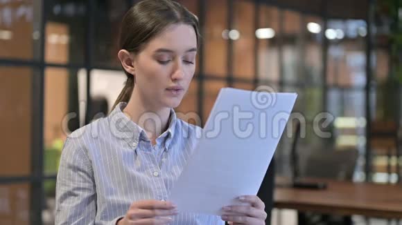 年轻女子通过阅读文件而心烦意乱视频的预览图