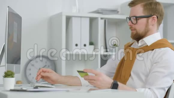 商人在电脑上输入信用卡信息视频的预览图