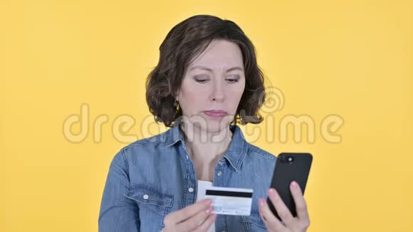 黄黄背景下老年女性智能手机在线支付视频的预览图