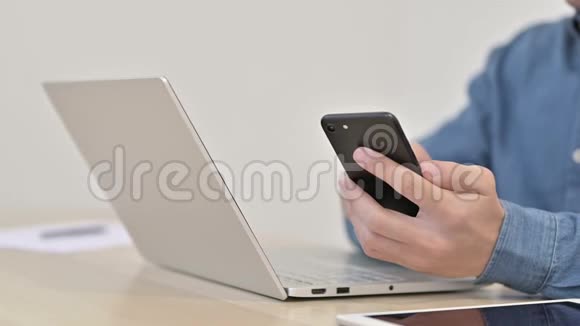 接近男人使用智能手机和笔记本电脑视频的预览图