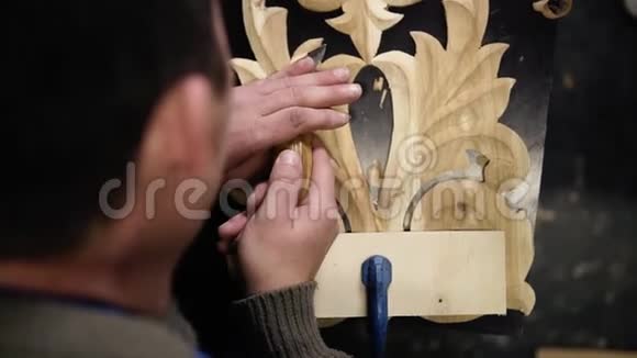 特写男人手中的镜头他正在一块木头图案上弯曲一个小细节工作中的花饰视频的预览图