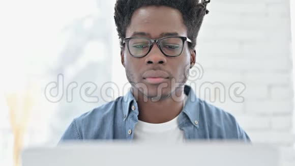 非洲青年男子在笔记本电脑上进行视频聊天的肖像视频的预览图