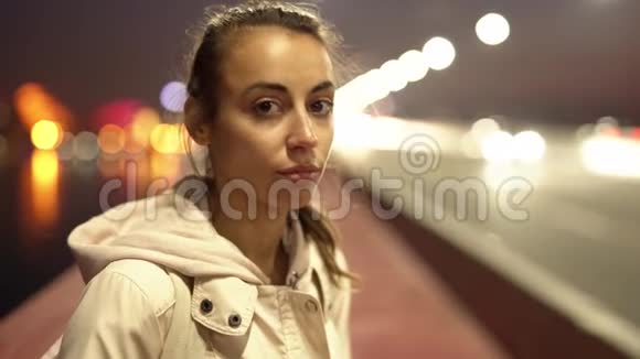特写美丽悲伤的年轻女子走在户外的夜晚城市慢镜头视频的预览图