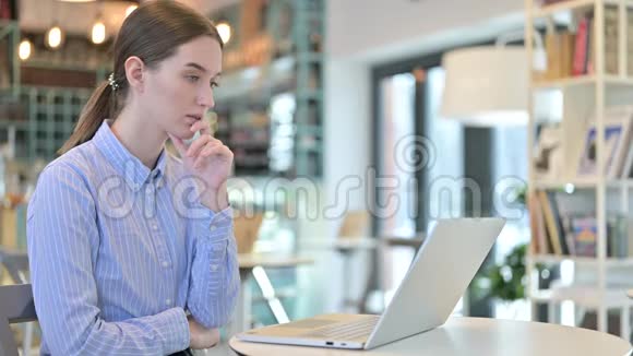 在咖啡馆使用笔记本电脑的体贴的年轻女商人视频的预览图