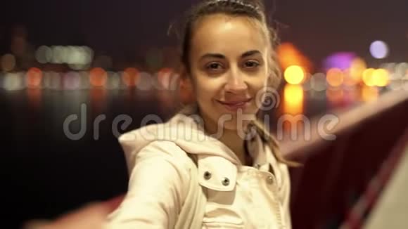 慢镜头美丽微笑的年轻女子走在户外的夜晚城市视频的预览图