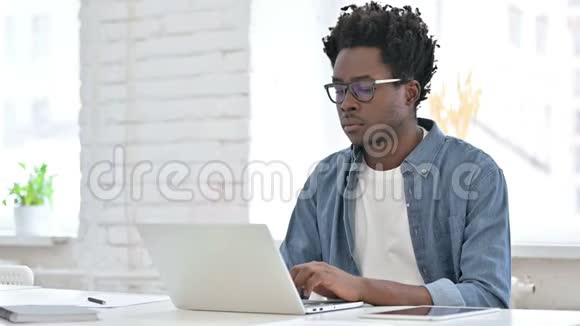 年轻的非洲男人在笔记本电脑上工作视频的预览图