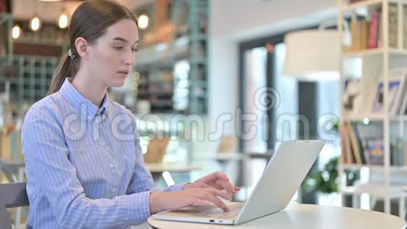 年轻女商人头痛在咖啡馆用笔记本电脑视频的预览图