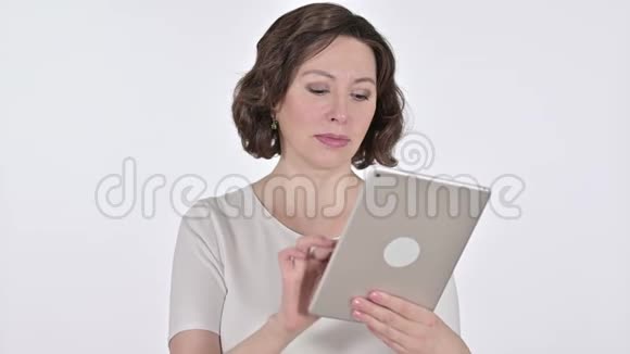 在白色背景下使用数码平板电脑的老妇人视频的预览图