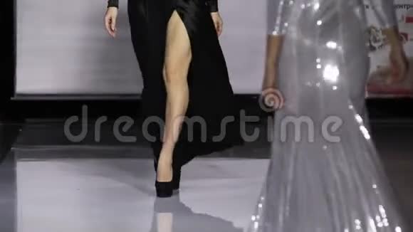 Defile漂亮女孩在T台模特秀上特写的黑色长裙慢动作4K视频的预览图