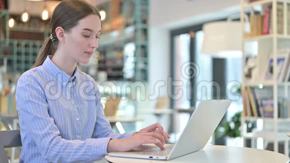 咖啡馆里漂亮的年轻女商人使用笔记本电脑视频的预览图