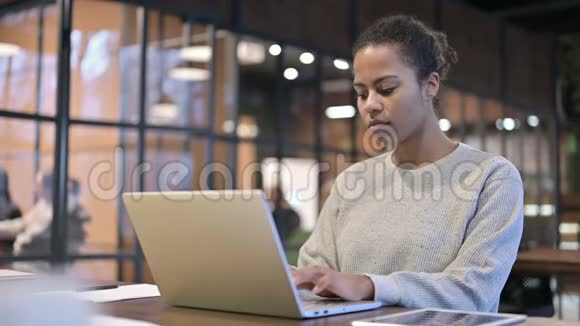在笔记本电脑上工作的非洲妇女背痛视频的预览图
