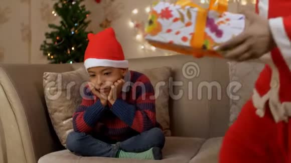 悲伤孤独的男孩从圣诞老人那里得到圣诞礼物视频的预览图