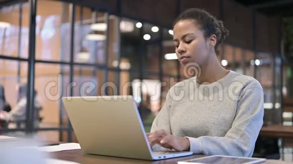 生病咳嗽的非洲妇女在笔记本电脑上工作视频的预览图
