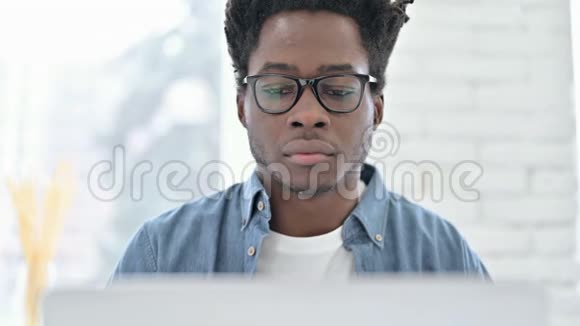 非洲年轻人在笔记本电脑上工作的画像视频的预览图