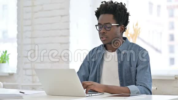年轻的非洲男人在办公室里背疼视频的预览图