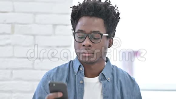 年轻的非洲男人用智能手机说话视频的预览图