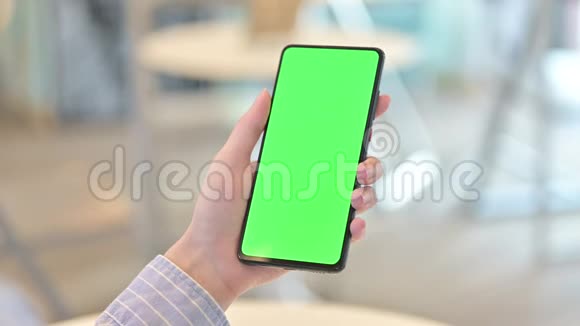 使用带有色度屏幕的智能手机的女性手的后视图视频的预览图