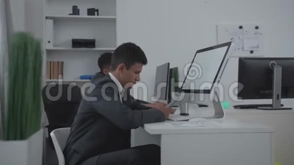 两个人坐在办公室的一张桌子旁视频的预览图