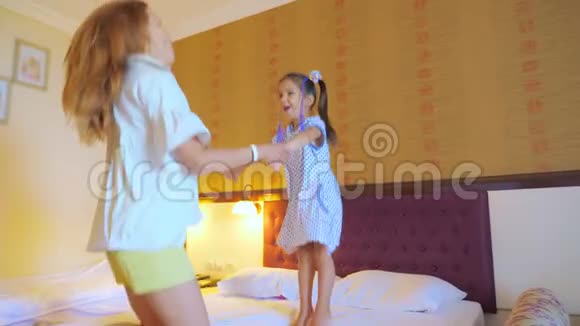 妈妈和女儿在酒店房间的床上跳视频的预览图
