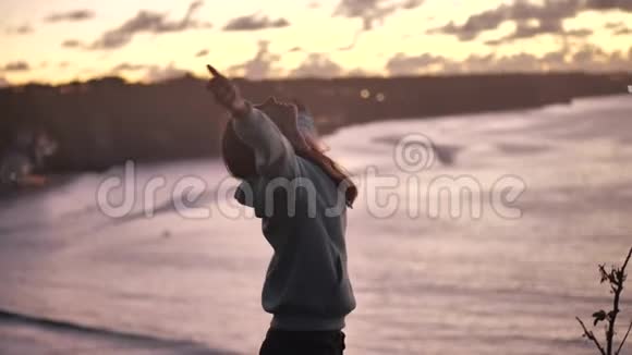 特写一幅美丽的年轻女子的肖像仰起双臂随风吹起头发在宁静的海边享受着视频的预览图