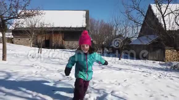 穿着冬装的孩子在雪地里奔跑的慢动作视频的预览图
