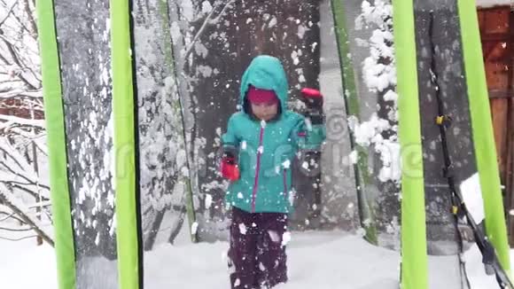 儿童在雪地蹦床上跳跃的慢动作视频的预览图