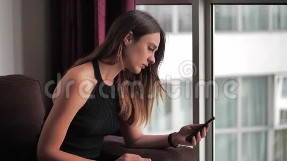 迷人的年轻女人在读她在哭的信息通过短信4k视频的预览图