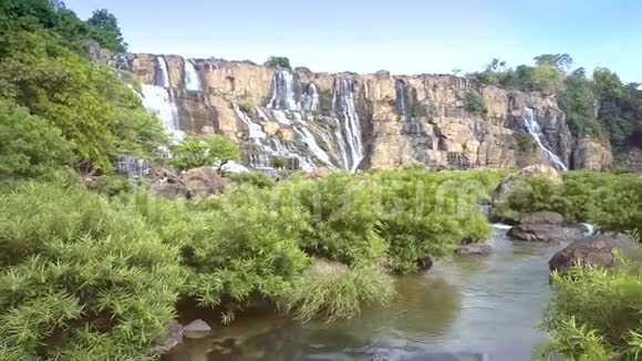 沿着河流运动两人坐在石头的背面瀑布视频的预览图