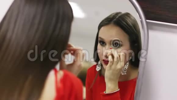 女人化妆镜特写美女画像刷止口霜视频的预览图
