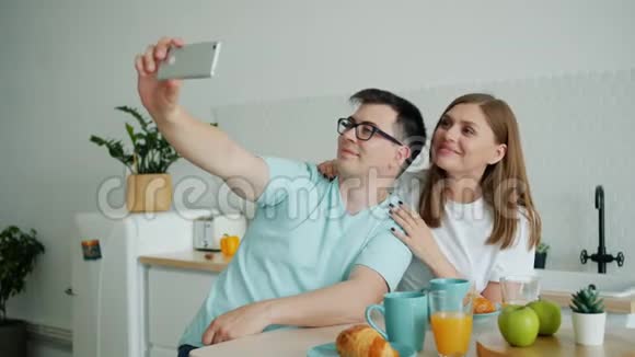 夫妻俩在厨房自拍用智能手机相机玩得开心视频的预览图