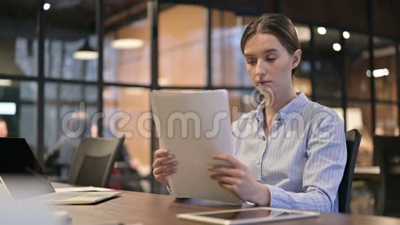 年轻妇女在工作中阅读文件文书工作视频的预览图