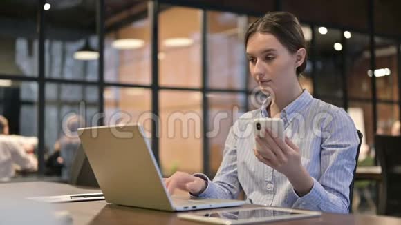 年轻女性使用智能手机和笔记本电脑视频的预览图