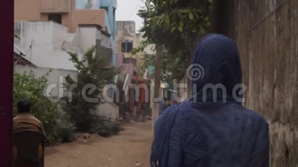 后景印度妇女穿着蓝色披肩走在狭窄的城市街道慢动作无法辨认的真实女孩视频的预览图