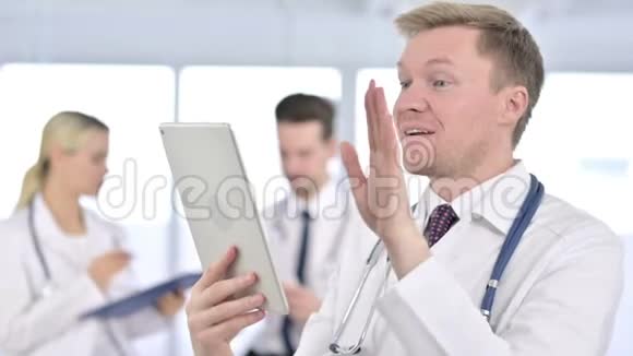 专业男性医生在平板电脑上进行视频聊天的画像视频的预览图