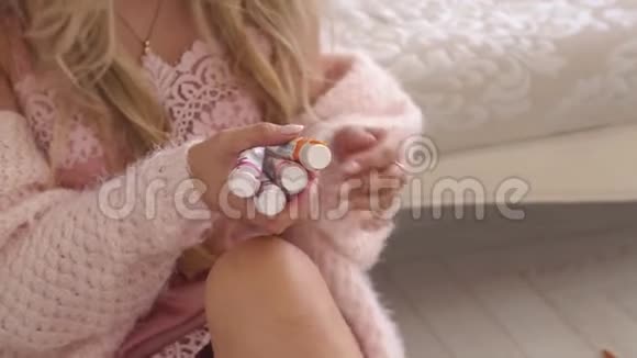 女孩艺术家穿着一件针织毛衣手里拿着许多管子的油画视频的预览图