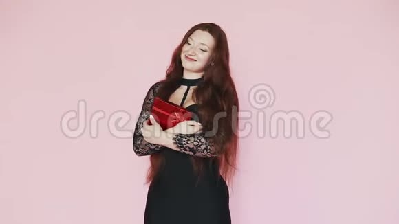 美丽的红发女孩站着把礼物压在胸前微笑节日的气氛3月8日慢动作视频的预览图