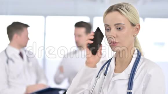 专业女医生在智能手机上说话的画像视频的预览图