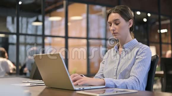 有颈部疼痛的女人做手提电脑视频的预览图