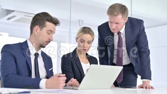严肃的专业团队讨论和处理笔记本电脑视频的预览图