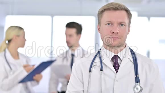 在镜头前微笑的男性医生的肖像视频的预览图