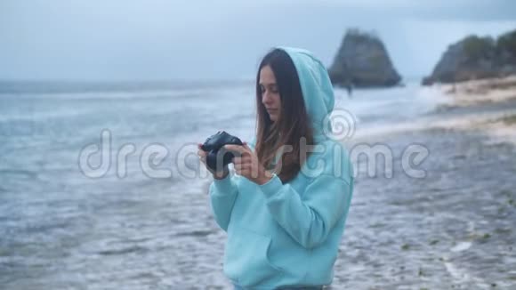 女孩拍摄照片视频dslr无镜相机海洋背景4k视频的预览图